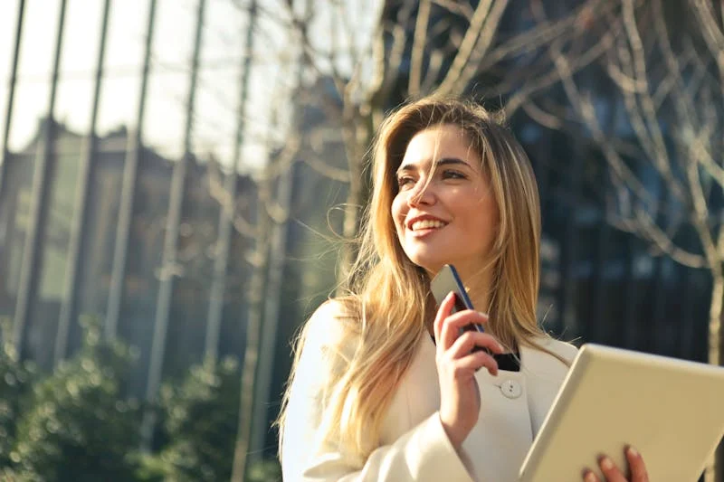 mujer emprendedora con su celular mirando hacia el horizonte